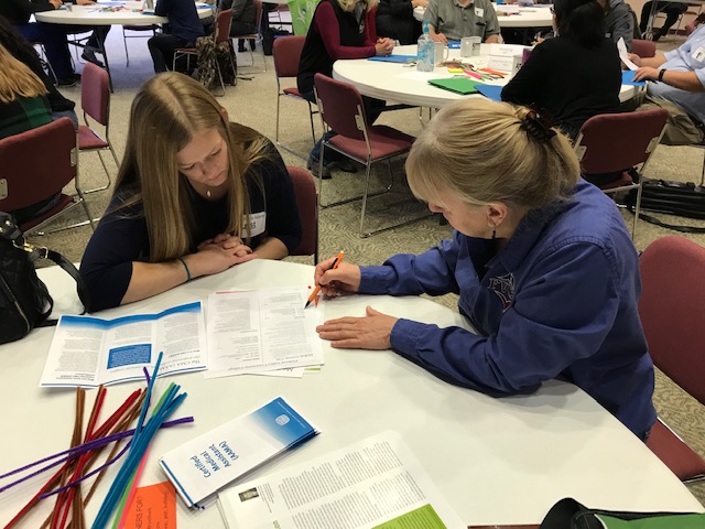 two women looking at a booklet together