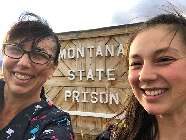 two women by montana state prison sign